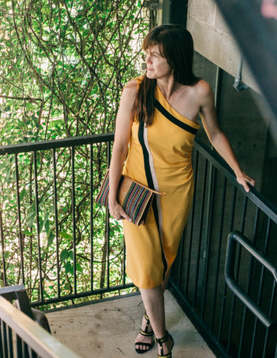 woman in yellow dress on stairway dressed for an evening out